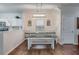 Bright dining area with a rustic table set, modern light fixture, white walls and hardwood flooring at 339 Iveson Rd, Summerville, SC 29486