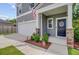 Inviting front porch with stone accents, an American flag, and neatly trimmed shrubs at 352 Matuskovic Dr, Charleston, SC 29414