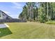 Beautiful backyard with lush green grass and tall trees in the distance at 354 Beachgrass Ln, Summerville, SC 29486
