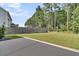 View of the backyard and fence with tall trees in the distance at 354 Beachgrass Ln, Summerville, SC 29486