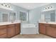 Bright bathroom featuring dual vanities, a large garden tub, modern fixtures, and ample natural light at 354 Beachgrass Ln, Summerville, SC 29486