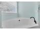 Bright bathroom featuring a relaxing white soaking tub and a window providing natural light at 354 Beachgrass Ln, Summerville, SC 29486