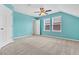 An empty bedroom is painted blue with carpeting, a ceiling fan, and two windows at 354 Beachgrass Ln, Summerville, SC 29486