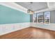 Dining room displaying wood floors, wainscoting, and designer lighting fixture at 354 Beachgrass Ln, Summerville, SC 29486