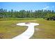 Outdoor fire pit with seating area overlooking a serene pond surrounded by lush green trees at 354 Beachgrass Ln, Summerville, SC 29486