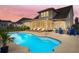 Backyard with in-ground pool, lounge chairs, fire pit, and screened porch at dusk at 404 Topcrest Ln, Moncks Corner, SC 29461