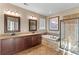 Bathroom featuring double vanity sinks, framed mirrors, soaking tub and glass enclosed shower at 404 Topcrest Ln, Moncks Corner, SC 29461