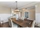 Bright dining room with hardwood floors, wainscoting, modern lighting, and view into the kitchen at 404 Topcrest Ln, Moncks Corner, SC 29461