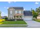 Charming two-story home with a well-manicured lawn, inviting front porch, and attached two-car garage at 404 Topcrest Ln, Moncks Corner, SC 29461