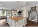 Kitchen island with granite countertop and white cabinets adjacent to the living room and stairs at 404 Topcrest Ln, Moncks Corner, SC 29461