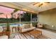Covered patio with comfortable seating, a ceiling fan, and a view of the pool and lush backyard at sunset at 404 Topcrest Ln, Moncks Corner, SC 29461