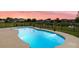 Backyard pool with concrete surround, adjacent to landscaped yard and black metal fence at 404 Topcrest Ln, Moncks Corner, SC 29461