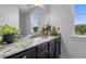 Sleek bathroom boasts marble countertops, dark wood cabinets, and ample natural light at 4419 Louisa Lane Ln, North Charleston, SC 29405