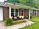 Charming front porch with a cozy seating area and landscaped flower bed at 4470 Farmwood Ct, Ladson, SC 29456