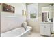 Bright bathroom featuring a clawfoot tub, tiled walls, and a window with natural light at 4626 O'Hear Ave, North Charleston, SC 29405