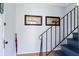 Light-filled entryway with hardwood floors, blue stairs, modern railing and charming wall decor at 4626 O'Hear Ave, North Charleston, SC 29405
