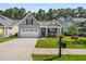 Well-maintained home with neat landscaping, a spacious driveway, and a cozy front porch for relaxing evenings at 491 Foxbank Plantation Blvd, Moncks Corner, SC 29461