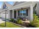 Inviting covered front porch with comfortable seating, lush landscaping, and stylish decor, perfect for relaxing at 491 Foxbank Plantation Blvd, Moncks Corner, SC 29461