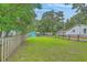 Large, fenced backyard with lush green grass and mature trees providing shade at 4928 Durant Ave, North Charleston, SC 29405