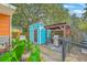 Relaxing backyard featuring an outdoor grilling area, blue shed, mature trees, and lush greenery at 4928 Durant Ave, North Charleston, SC 29405