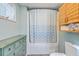 Compact bathroom featuring a bathtub with shower and blue curtain, and small cabinet at 4928 Durant Ave, North Charleston, SC 29405