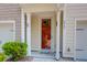 Close-up of townhome's red front door with address, surrounded by white columns and manicured shrubs at 4964 Hay Bale Ct, Summerville, SC 29485