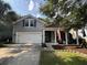 Charming two-story home with gray siding, a two-car garage, and a welcoming front porch with American flags at 5008 W W Liberty Meadows Dr, Summerville, SC 29485