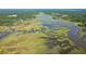 Wide aerial view of marshland with wooden piers, serene waterways, and homes surrounded by lush greenery at 5084 Timber Race Crse, Hollywood, SC 29449