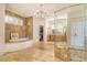 Bright bathroom with stone floors, soaking tub, glass shower, and large vanity at 5084 Timber Race Crse, Hollywood, SC 29449