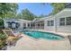 Backyard pool area with lounge chairs and outdoor dining set and white brick architecture at 5084 Timber Race Crse, Hollywood, SC 29449
