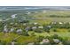 Expansive aerial shot capturing homes on a lush golf course beside the winding marshy waterfront at 55 Seagrass Ln, Isle of Palms, SC 29451