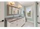 Charming bathroom with double sinks, granite countertops, a decorative mirror, and a step-in shower at 55 Seagrass Ln, Isle of Palms, SC 29451