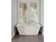 Relaxing bathroom featuring a white soaking tub and window with shutters at 55 Seagrass Ln, Isle of Palms, SC 29451