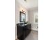 Modern bathroom with dark cabinets, granite countertop, decorative mirror, and gray tile floors at 55 Seagrass Ln, Isle of Palms, SC 29451
