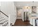 Elegant hallway leads to a modern kitchen with stainless steel appliances and a marble countertop island at 55 Seagrass Ln, Isle of Palms, SC 29451
