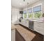 Bright kitchen with stainless steel appliances, patterned runner, and large windows overlooking greenery at 55 Seagrass Ln, Isle of Palms, SC 29451