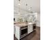 Kitchen island featuring a double oven, marble countertop, pendant lights, and ample storage space at 55 Seagrass Ln, Isle of Palms, SC 29451