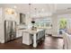 Modern kitchen featuring stainless steel appliances, a central island, and seamless connection to the dining area at 55 Seagrass Ln, Isle of Palms, SC 29451