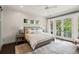 Spacious main bedroom with shiplap accent wall features a ceiling fan, French doors to the balcony, and neutral decor at 55 Seagrass Ln, Isle of Palms, SC 29451