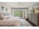 Sun-filled main bedroom with shiplap wall features a ceiling fan, private balcony, and light, neutral decor at 55 Seagrass Ln, Isle of Palms, SC 29451