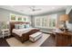 Sun-filled main bedroom with a wicker bed, a ceiling fan, and shutters on the many windows at 55 Seagrass Ln, Isle of Palms, SC 29451