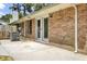 Brick exterior with a concrete patio and sliding glass doors, set against a backdrop of lush greenery at 703 Temple Rd # A, Ladson, SC 29456