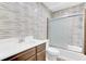 Modern bathroom featuring textured tile walls, a sliding glass shower door, and wooden cabinets at 703 Temple Rd # A, Ladson, SC 29456