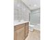 Modern bathroom featuring a sleek vanity with warm wood tones, stylish wave-patterned tiles, and a glass-enclosed shower at 703 Temple Rd # A, Ladson, SC 29456