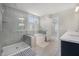 Bright bathroom featuring a bathtub, glass shower, and light gray tile at 7045 Stonecrop Ln, Johns Island, SC 29455