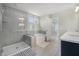 Bright bathroom featuring a bathtub, glass shower, and light gray tile at 7045 Stonecrop Ln, Johns Island, SC 29455