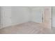 An empty bedroom with door to an adjacent room and neutral carpet at 7045 Stonecrop Ln, Johns Island, SC 29455