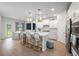 Open-concept kitchen featuring a large island with bar seating, adjacent to a sunlit dining area at 7045 Stonecrop Ln, Johns Island, SC 29455