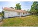 Spacious backyard with a white brick house, red roof, secure fencing, and a small patio area with flower boxes at 747 Brant Rd, Charleston, SC 29414