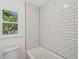 Updated bathroom with white subway tile shower, new toilet, and window with backyard view at 747 Brant Rd, Charleston, SC 29414
